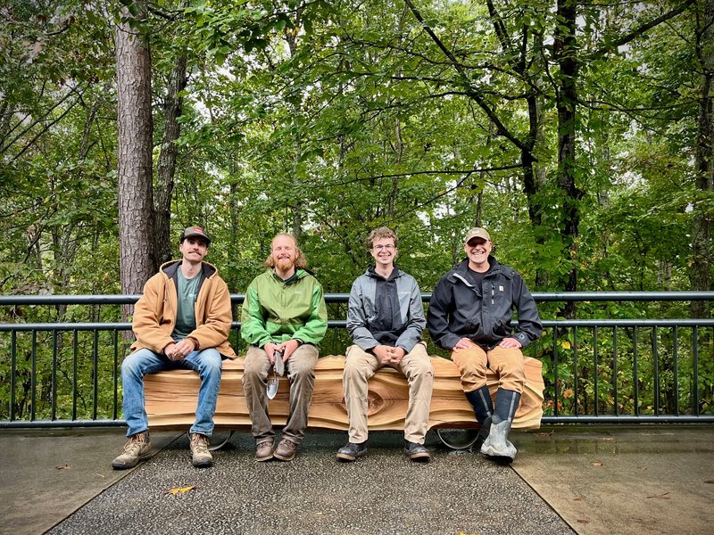 People seated on the Topographical Bench by Chester Shuey at the North Carolina Arboretum
