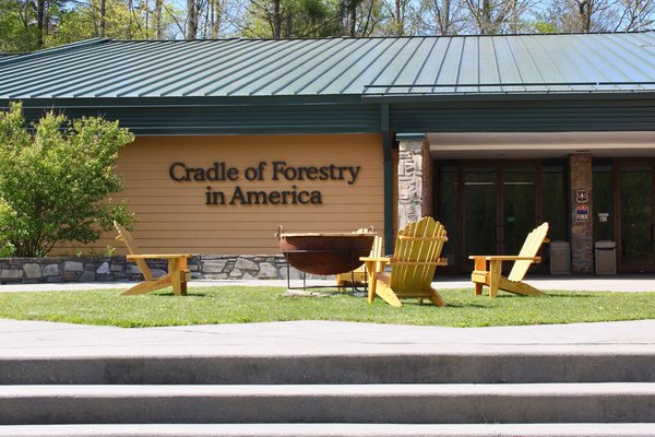 The Cradle of Forestry in America visitor center in Pisgah National Forest, with wooden Adirondack chairs out front
